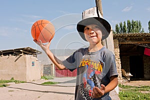 KYRGYZSTAN: Boy in national hat plays basketball