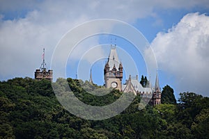 KÃ¶nigswinter, Germany - 06 28 2022: Schloss Drachenburg behind trees