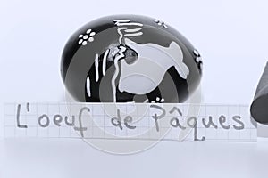 L`oeuf de Paques, French word on a white note for English Easter Egg