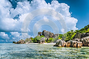 La Digue island, Seychelles. Beautiful vacation cloudscape on paradise Anse Source d`Argent beach with shallow blue