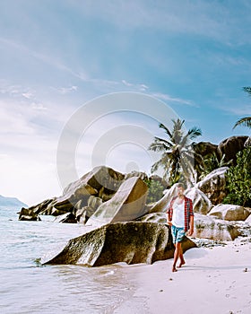 La Digue Seychelles, young men on vacation at the tropical Island La Digue, mid age guy walking on the beach during