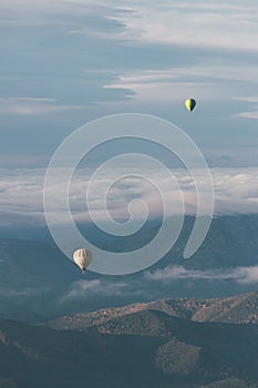 La Garrotxa Landscape from above with two hot air balloons flying over the clouds and the volcanic zone.