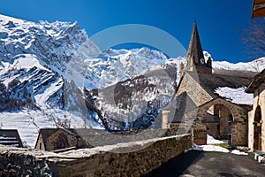 La Grave Ecrins National Park. The church of Notre Dame de l`Assomption de la Grave in winter with La Meije Peak. Autes-Alpes