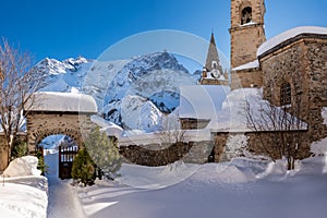 The local village of La Grave and its church with La Meije mountain peak in Winter. Hautes-Alpes, Ecrins National Park, France photo