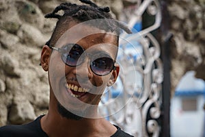 La Havana, Cuba, January 08, 2017: Portrait of a black cuban man with sunglasses on street from la Havana. Afrocaribbean rasta cu