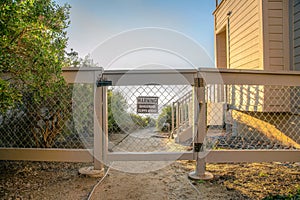 La Jolla, California- Gate and fence with mesh wire and signage with warning