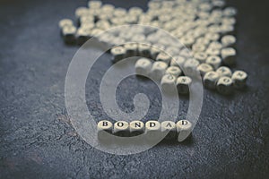 The word kindness written with wooden cubes on a black background