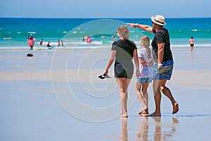 Father with his daughters at a famous surfer beach in Brittany, France