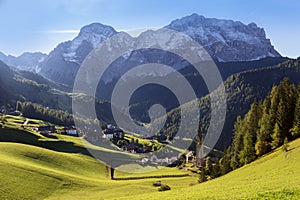 La Vale Valley - Italian Dolomites, a small village in the mountains, right next to a high forest stands a slender church. In the