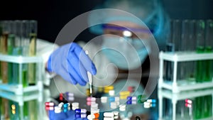 Lab assistant analyzing medication capsules, counterfeit pharmaceuticals, study photo