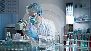 Lab assistant studying samples to detect pathologies, quality medical research