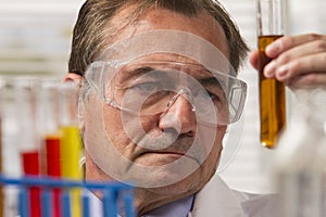 Lab scientist examining test tube, horizontal