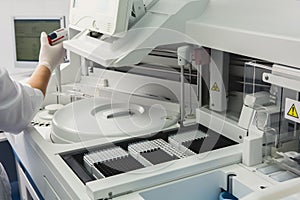 Lab tech loading samples into a chemistry analyzer