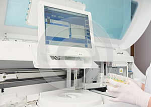 Lab tech loading samples into a chemistry analyzer