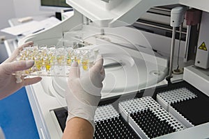 Lab tech loading samples into a chemistry analyzer