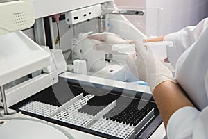 Lab tech loading samples into a chemistry analyzer