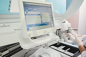 Lab tech loading samples into a chemistry analyzer