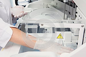 Lab tech loading samples into a chemistry analyzer