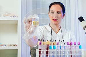 Lab technician assistant analyzing urin sample at laboratory. photo