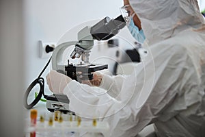 Lab technician examining an antiviral drug through the microscope