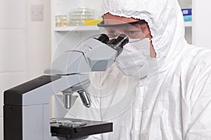 Lab technician looking through a microscope