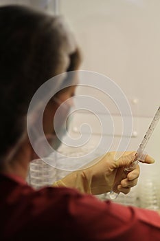 Lab technician measuring a liquid in a laboratory.
