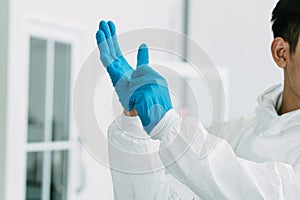 Lab Technician in Personal protective equipment  PPE suit wearing the gloves