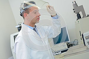 Lab technician raising visor mask