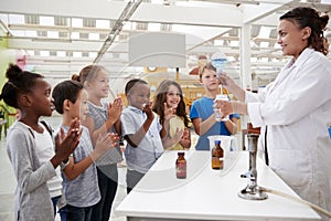 Lab technician showing excited kids a science experiment