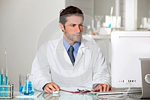 Lab technician studying results on a computer