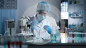 Lab worker dripping sample onto laboratory glass to research cloning process