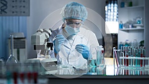 Lab worker dripping sample onto laboratory glass to research cloning process photo