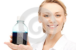 Lab worker holding up bottle with blue liquid