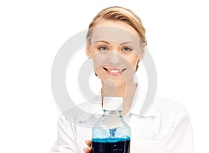 Lab worker holding up bottle with blue liquid
