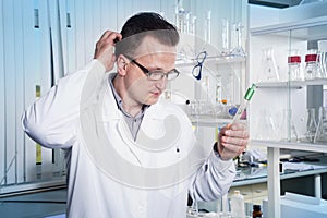 Lab worker in observing test tube with mold at the laboratory