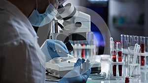 Lab worker preparing glass with blood for detection of antibodies and infections