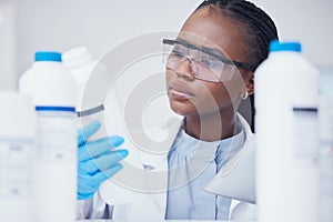 Label check tablet, chemical bottle and black woman scientist with mask at pharmaceutical lab. Research, digital reading