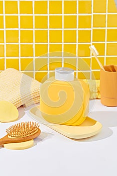 A label-free yellow shower gel bottle stands on a white table against a checkered tile backdrop. Perfectly showcase shower gel in