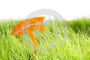 Label With German Willkommen Which Means Welcome On Green Grass