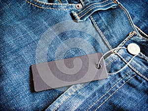 Label gray price tag mockup on blue jeans.