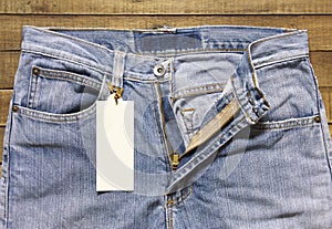 Label tag and jeans on wood background