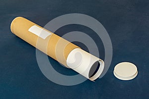 Labelled packaging tube for deliveries with end cap and rolled up paper contents photo