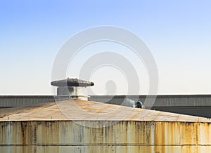 Laber welding on rooftop of big store tank.