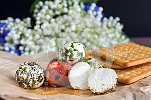 Labne balls with herbs and spices and crackers on kraft paper. Traditional yogurt cream cheese in the Middle East.