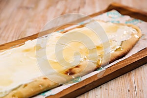 Labneh with asal pizza bread served in wooden board  on background top view of Arabic Manaqeesh