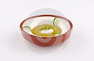 Labneh bowl on white background with cucumber