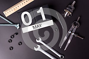 Labor day. May 1st. Day 1 of may month, calendar on black background with workers tools