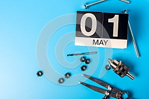 Labor day. May 1st. Day 1 of may month, calendar on blue background with tools. Empty space for text