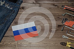 Labor Day in Russia, May 1. A lot of handy tools on a dark wooden background with the flag of Russia with copy space