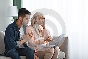 Labor And Delivery Fears. Worry Muslim Couple Watching Childbirth Videos On Laptop